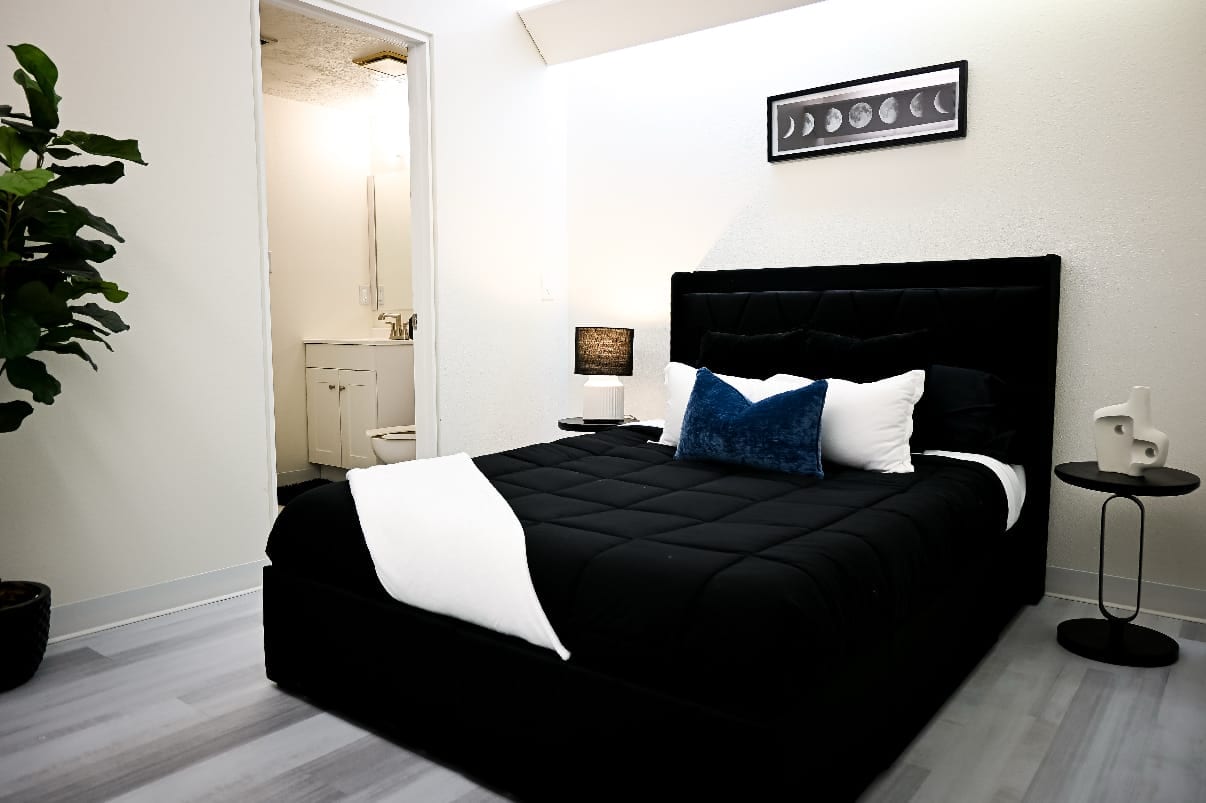 Private residential bedroom with a made bed and an ensuite bathroom at Ascend Recovery Center Albuquerque