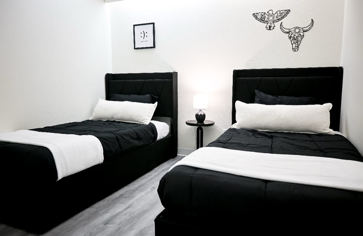 Shared residential bedroom with two beds and Southwestern artwork at Ascend Recovery Center Albuquerque